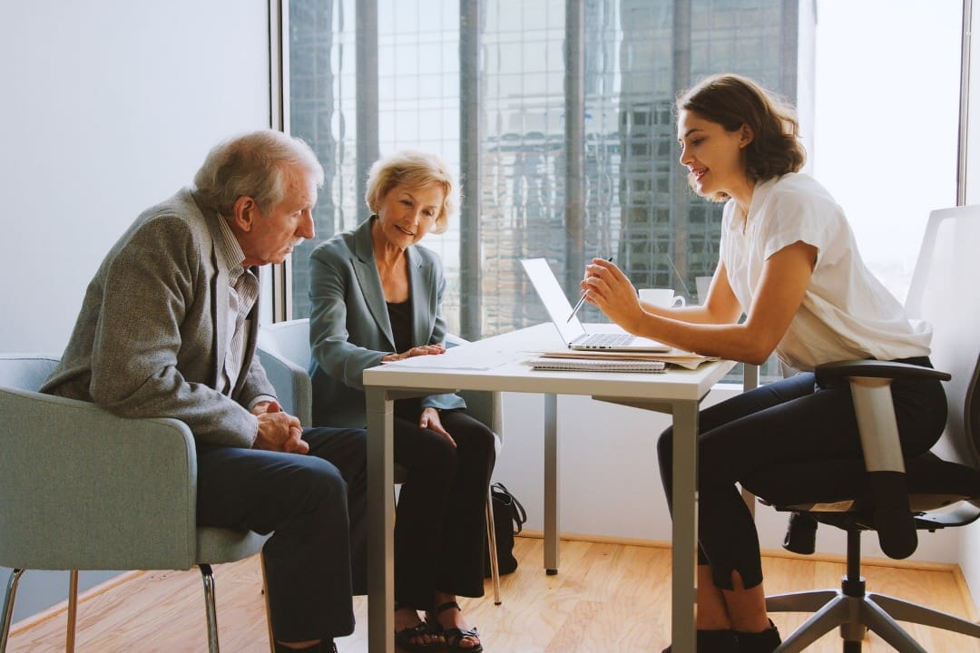 Medicare insurance agent meeting with clients prospects beneficiaries in office
